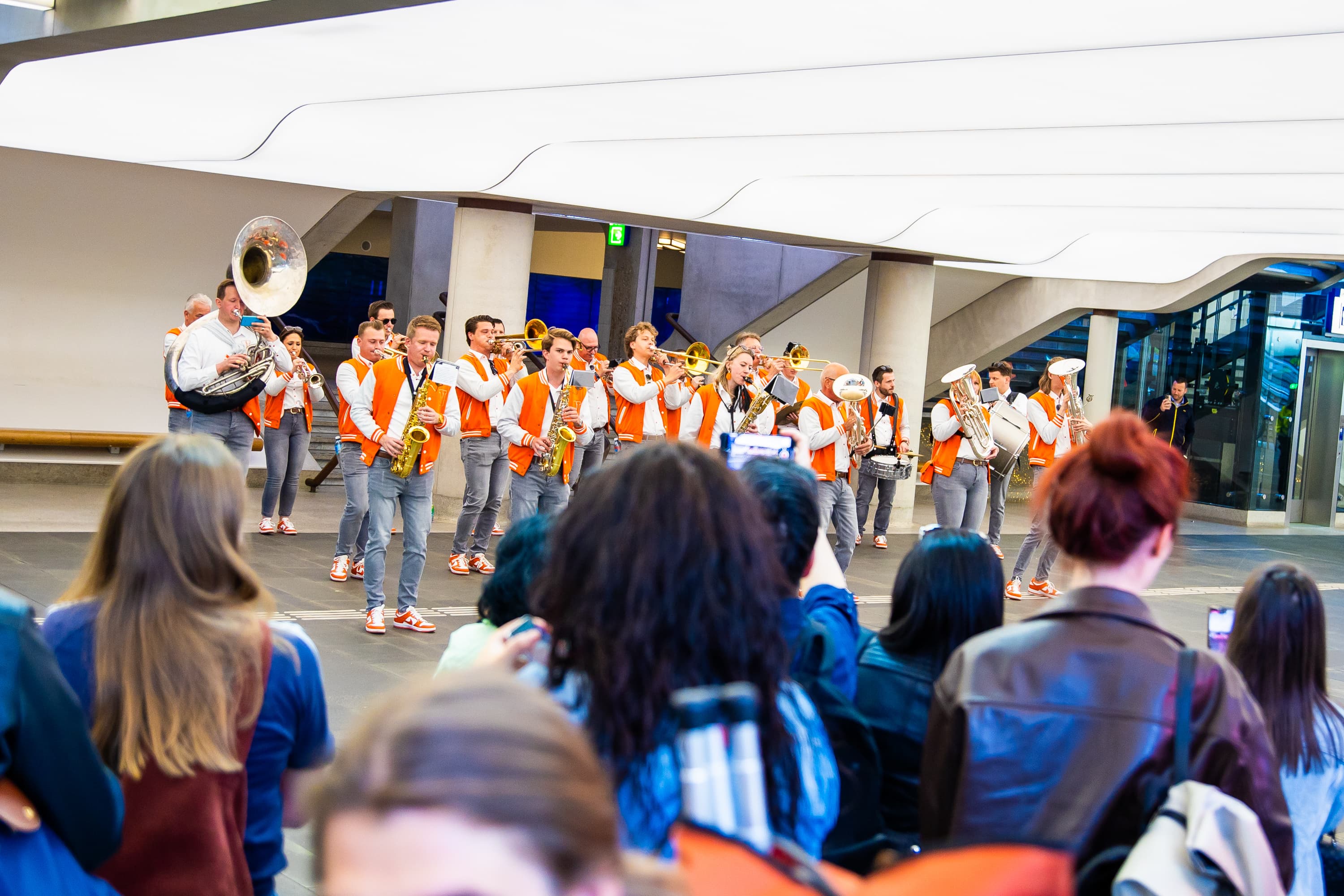 Navenant in oranje outfits op een plein